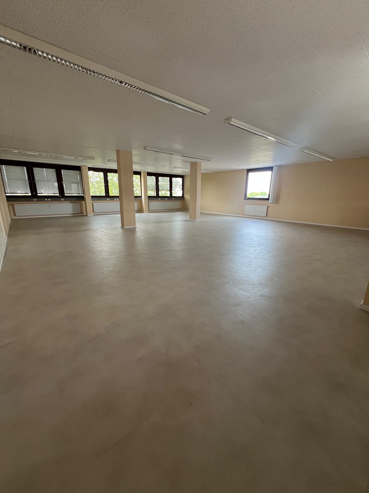 Heller zukünftiger Yogaraum mit großen Fenstern